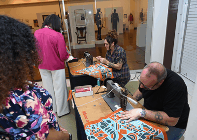 Ranger Stitch adds names to bandanas at the 2024 Rural Renaissance Roadshow